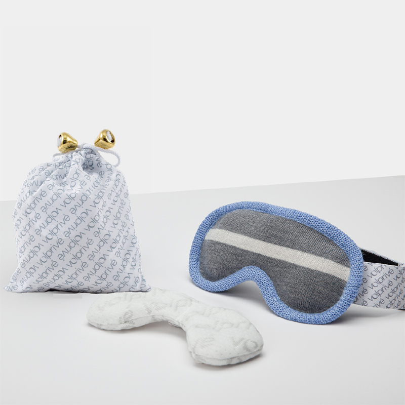 A blue and grey sleep mask with a white  patterned bag