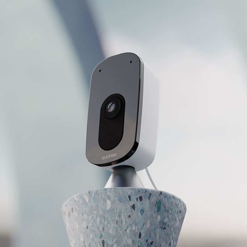 A small indoor smart camera perched on a stand 