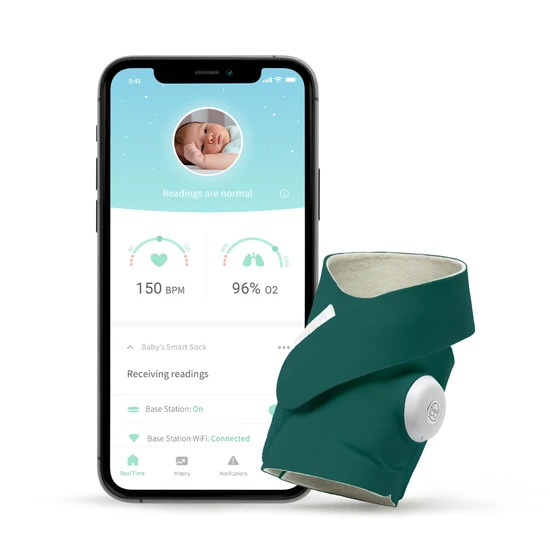 A phone screen with a baby monitor app on it next to Owlet's Smart Sock