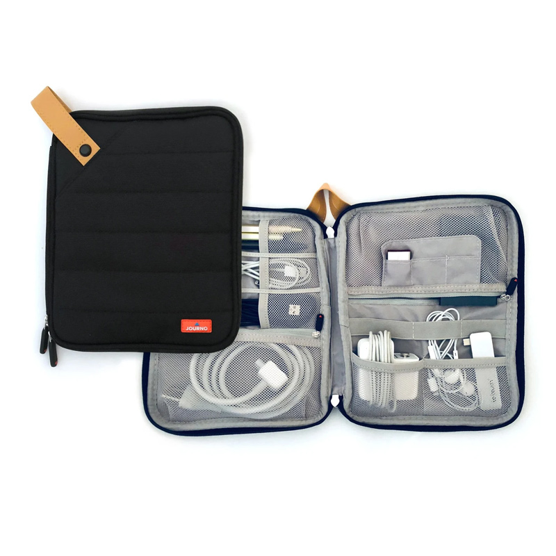 An open tech travel organizer with phone cords and laptop chargers inside 