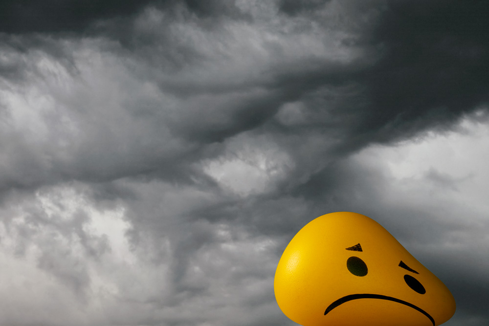 An illustration of a smiling face frowning in a dark sky 