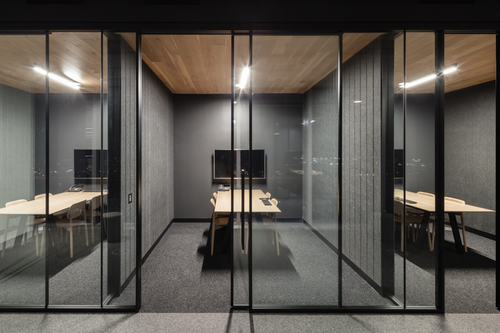 A photo of a dark private meeting room with a wooden table inside 